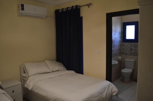 a small bedroom with a bed and a bathroom at Pool View Chalet in El Alamein