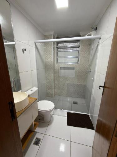a bathroom with a shower and a toilet and a sink at Lindo Apartamento na Guilhermina PG in Praia Grande