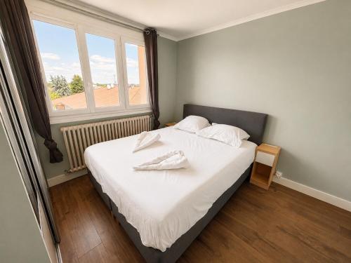 a bedroom with a bed with white sheets and a window at Le Panorama Chic 4prs-Parking in Bourg-en-Bresse