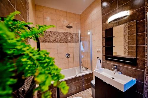a bathroom with a sink and a shower and a toilet at HL Łebski Apartamenty in Łeba