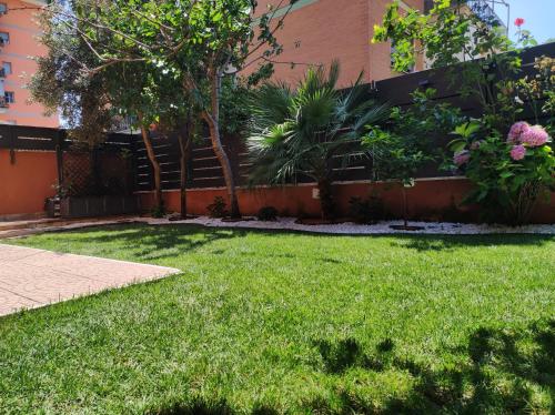 a yard with green grass and a building at Eden Bay Vacation Home in Ladispoli