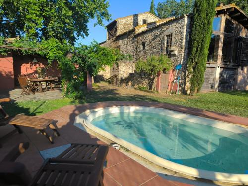 a swimming pool in the yard of an old building at Can Cirili Rustic Romantic apartment for couples or family events in Bordils