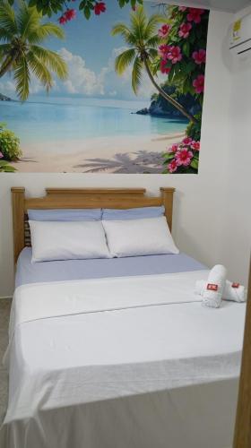 a bed in a room with a painting on the wall at Hotel Panther Resort in Necoclí