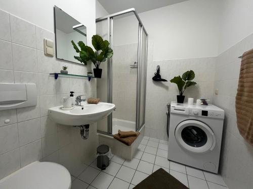 a bathroom with a sink and a washing machine at Stylische Flat1 mit französischem Balkon1 all-in 5G in Gera