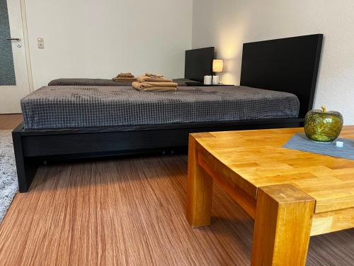 a bedroom with a bed and a wooden table at Stylische Flat1 mit französischem Balkon1 all-in 5G in Gera
