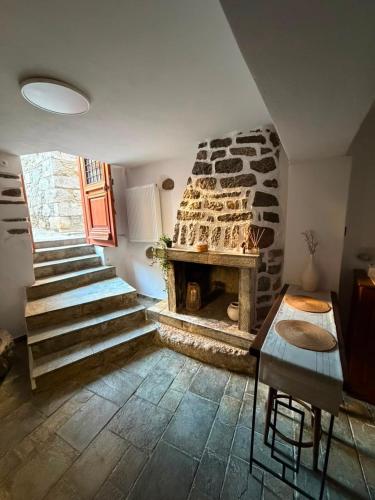 a living room with a stone fireplace and stairs at Dukes place in Mestá