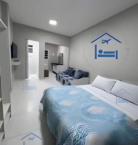 a bedroom with a large bed and a living room at Estadia Perfeita com AC, Apto a minutos do Aeroporto Gru in Guarulhos