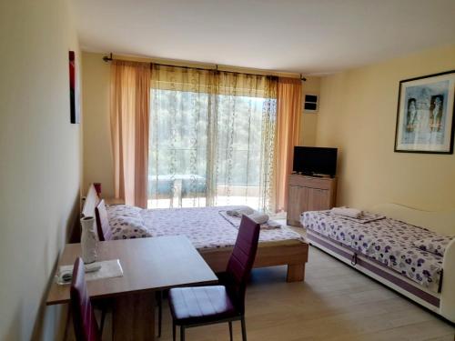 a room with two beds and a table and a window at Apartments M&Z in Budva