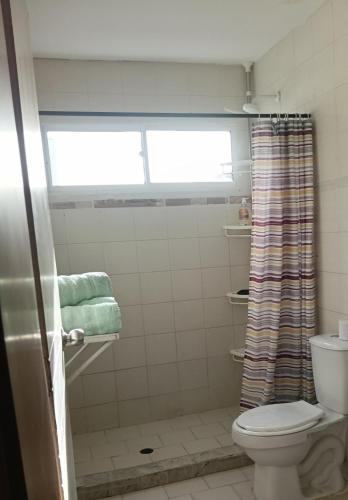 a bathroom with a toilet and a window at Apartamento Victoria B in Ríohacha