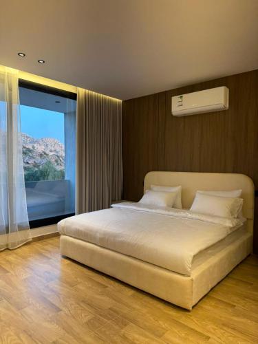ein Schlafzimmer mit einem großen Bett und einem großen Fenster in der Unterkunft رأس الشفا - OrbitNet in Al Shafa