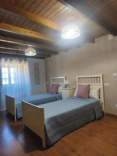 two beds in a room with two lights at Casa Pancha in Cerdeda