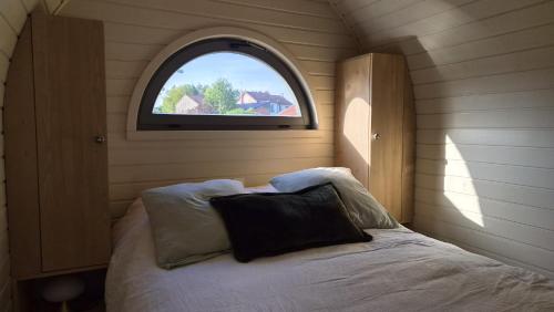 a small bedroom with a bed and a window at Les Lodges de la Moivre in Saint-Jean-sur-Moivre