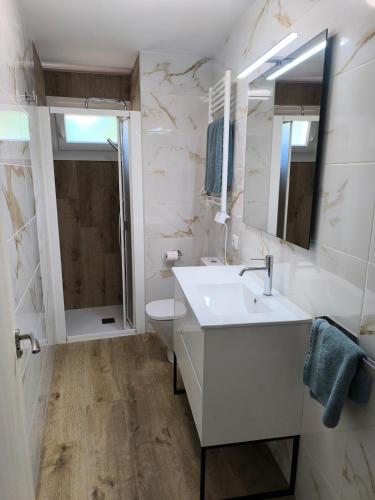 a white bathroom with a sink and a toilet at VuT El Mirlo in Frías