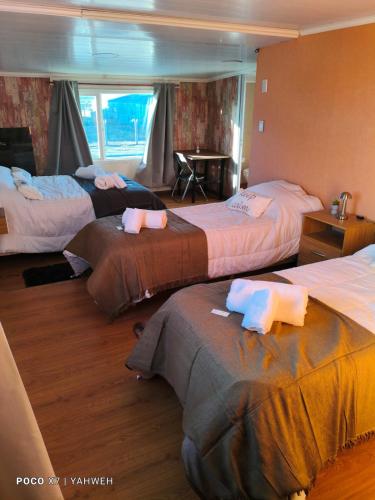 a hotel room with three beds with towels on them at Yahweh in Río Grande