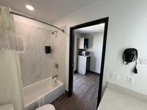 a bathroom with a shower and a tub and a sink at Crescent Inn in Wilmington