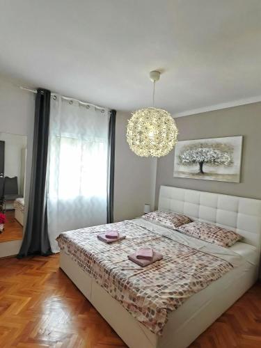 a bedroom with a bed and a chandelier at Sun house in Krk