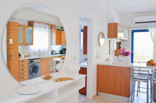 a kitchen with white counters and a mirror at Angie's Serenity Apartment in Vathí