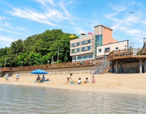 a group of people on a beach near the water at Yeongheungdo Haevichi Pension in Incheon