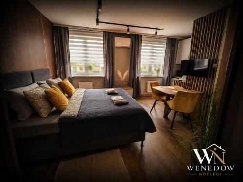 a bedroom with a bed and a table and a television at 205 Wenedow Noclegi in Koszalin