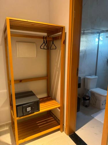 a small refrigerator with a clock in a bathroom at UMARI Reserva Hotel in Marituba