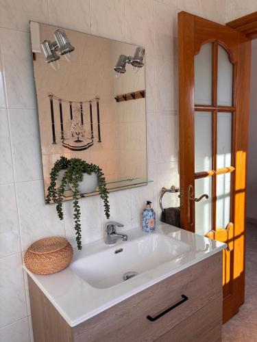 a bathroom with a white sink and a mirror at Cumbre- chalet con piscina cubierta y vistas al mar en Sada in Sada