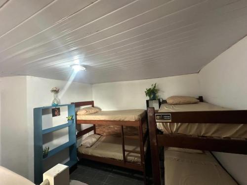 a room with two bunk beds and a light at Vista Surf Pipa Hostel in Pipa