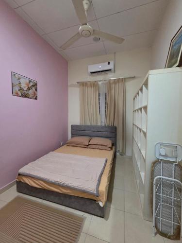 a bedroom with a bed and a ceiling fan at Ctr Ruby homestay in Shah Alam