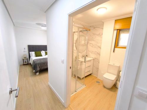 a bathroom with a toilet and a bed in a room at Casa Gaia Centrally located accommodation with spacious rooms in Redondela