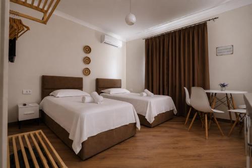 a hotel room with two beds and a table at Villa Reve de Tirana in Tirana