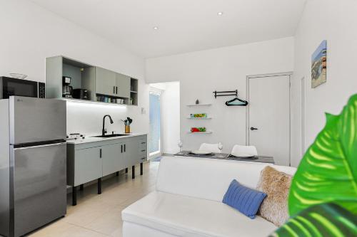 a white kitchen with a white couch in a room at Villa Sirena Azul Apt 1 in Palm-Eagle Beach