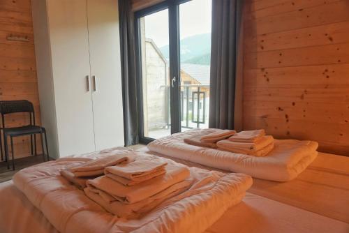 two beds sitting in a room with a large window at Nassfeld Holiday Home in Rattendorf