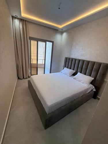 a bedroom with a large bed with white sheets at اقامة هبة 4 in Yebha