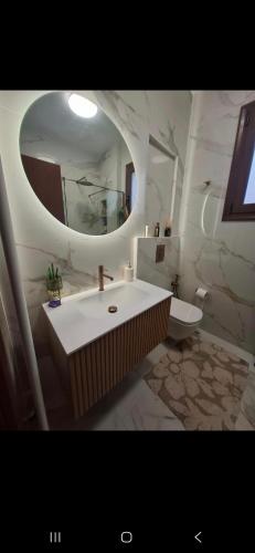 a bathroom with a large sink and a mirror at SuiteViewPoros-Luxury Apartment in Galatas in Galatas
