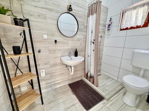 a bathroom with a sink and a toilet and a mirror at Apartments Fortuna in Biograd na Moru