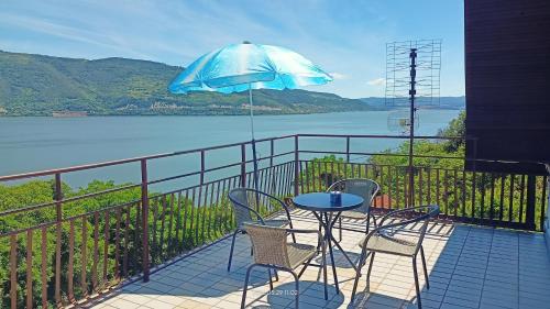 a patio with a table and chairs and an umbrella at Apartman Đurić in Donji Milanovac
