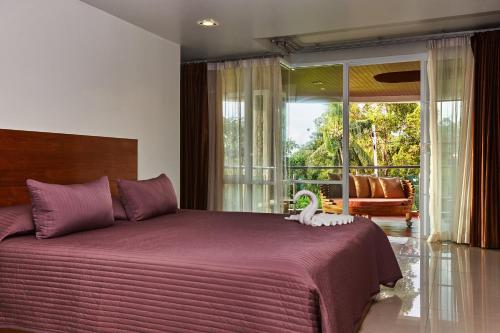 a bedroom with a large bed with a large window at NB Villa Vimana in Bang Rak Beach