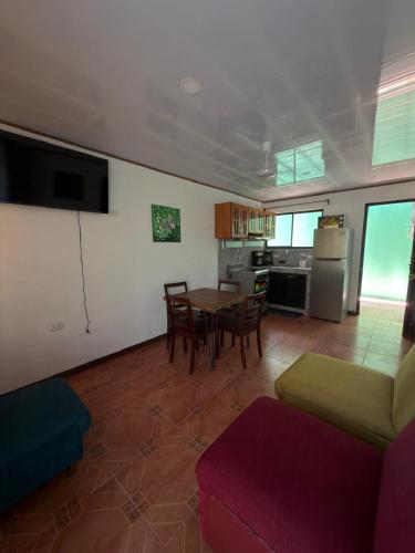 a living room with a table and chairs and a kitchen at Mi rinconcito en Liberia in Liberia