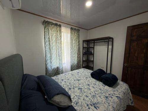 a bedroom with a bed with blue pillows on it at Mi rinconcito en Liberia in Liberia