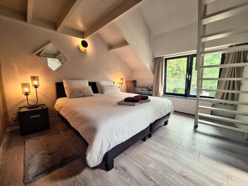 a bedroom with a large bed and a large window at Lakeview in Keerbergen