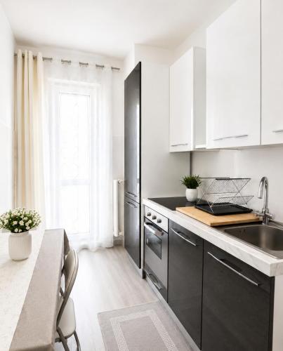 a kitchen with black and white cabinets and a sink at Liam House - Stanza 2 in Limbiate