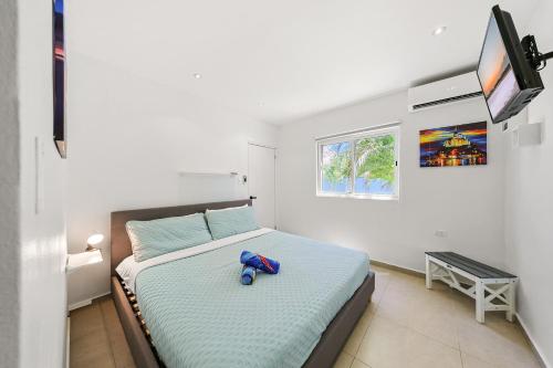 a bedroom with a bed with a blue toy on it at Villa Sirena Azul Apt 2 in Palm-Eagle Beach