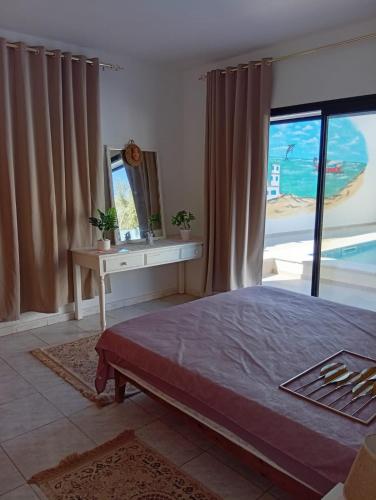 a bedroom with a bed and a table and a mirror at Djerba Moon in Djerba