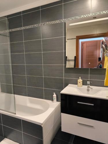 a bathroom with a sink and a tub and a mirror at Vacaciones en el paraíso in Lagoa