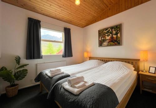 a bedroom with a large bed and a window at Engimyri Lodge in Akureyri