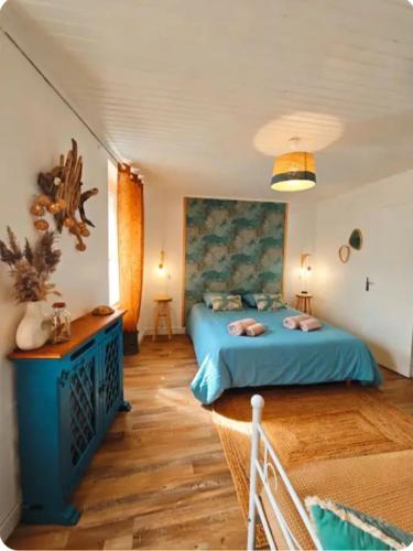 a bedroom with a blue bed in a room at Le Clos de Saint Georges in Saint-Georges-dʼOléron