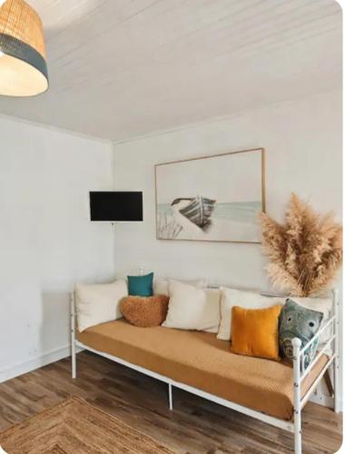 a living room with a couch with pillows on it at Le Clos de Saint Georges in Saint-Georges-dʼOléron