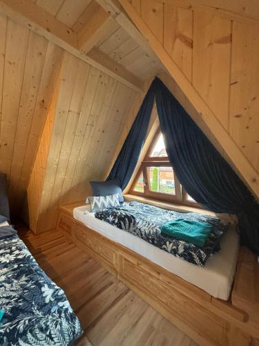 ein Schlafzimmer mit einem Bett in einer Holzhütte in der Unterkunft Bustryk 33 in Bustryk