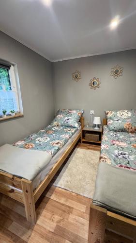 a bedroom with two beds and a window at Domki na Wesołej 2 in Połczyno