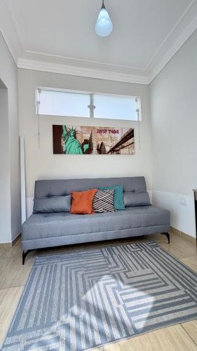 a blue couch in a room with a rug at Espaço Primavera in Pouso Alegre