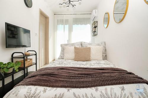 a bedroom with a large bed and a tv at B-Two10 in Balatonlelle